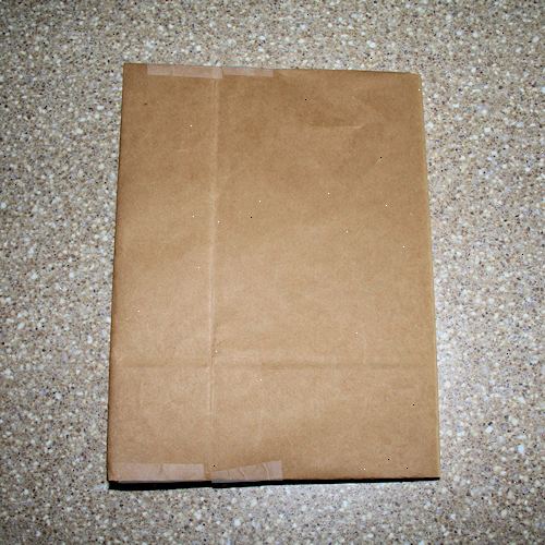 Hvordan lage en papirpose bokomslag. Klipp opp et brunt papir shopping bag langs en ​​søm.